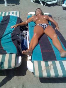 Topless Oiled Up MILF On The Beachw7rf8ne0en.jpg